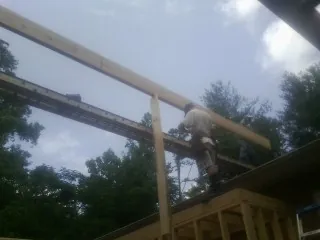 Carpenter setting a ridge beam over a new addition frame — Ice Dam Removal by Roofing Brothers in Brandy Station