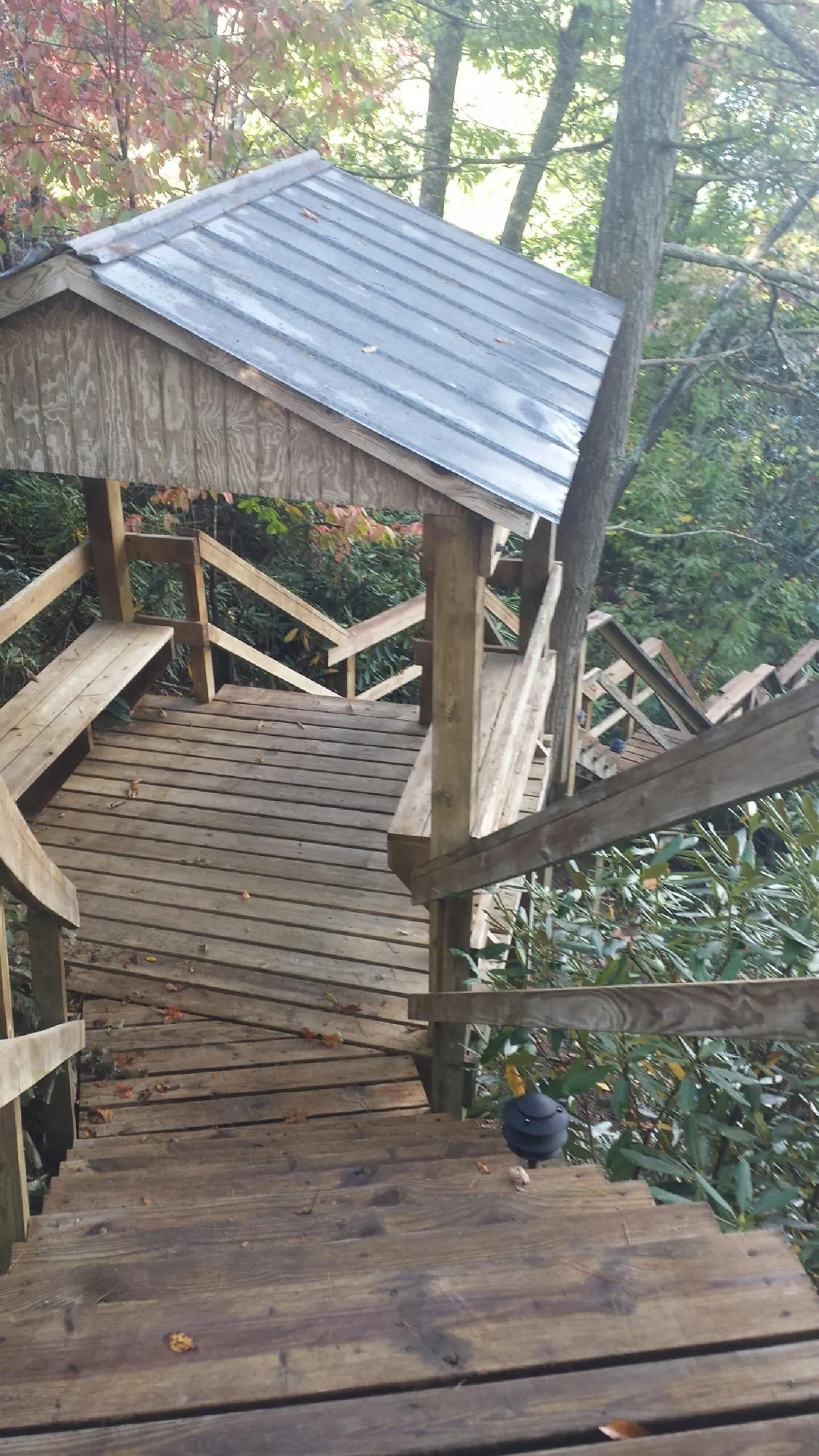 Metal roofed shelter over wooden steps on a wooded walkway — Skylight Repair & Installation work by our crew in Brandy Station